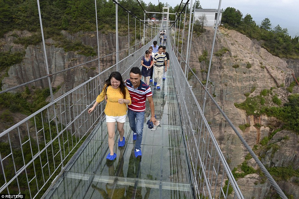 A bridge too far: Terrified tourists struggle to walk across China’s new glass-bottom walkway suspended 600 FEET above the ground